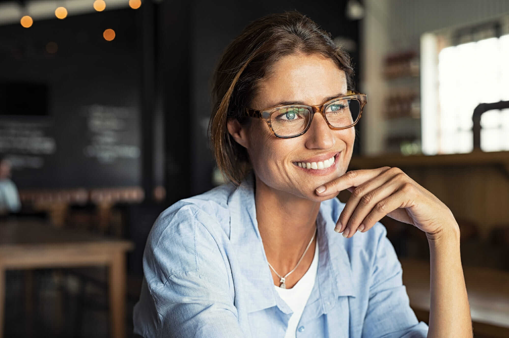 Woman Sitting in a coffee shop Mile High Psychology Example of woman showing the positive results of individual therapy for personal growth