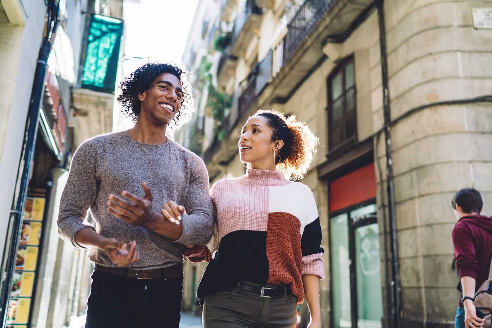 Couple walking and talking in city Mile High Psychology Couple connecting on a walk as an example of our therapeutic services