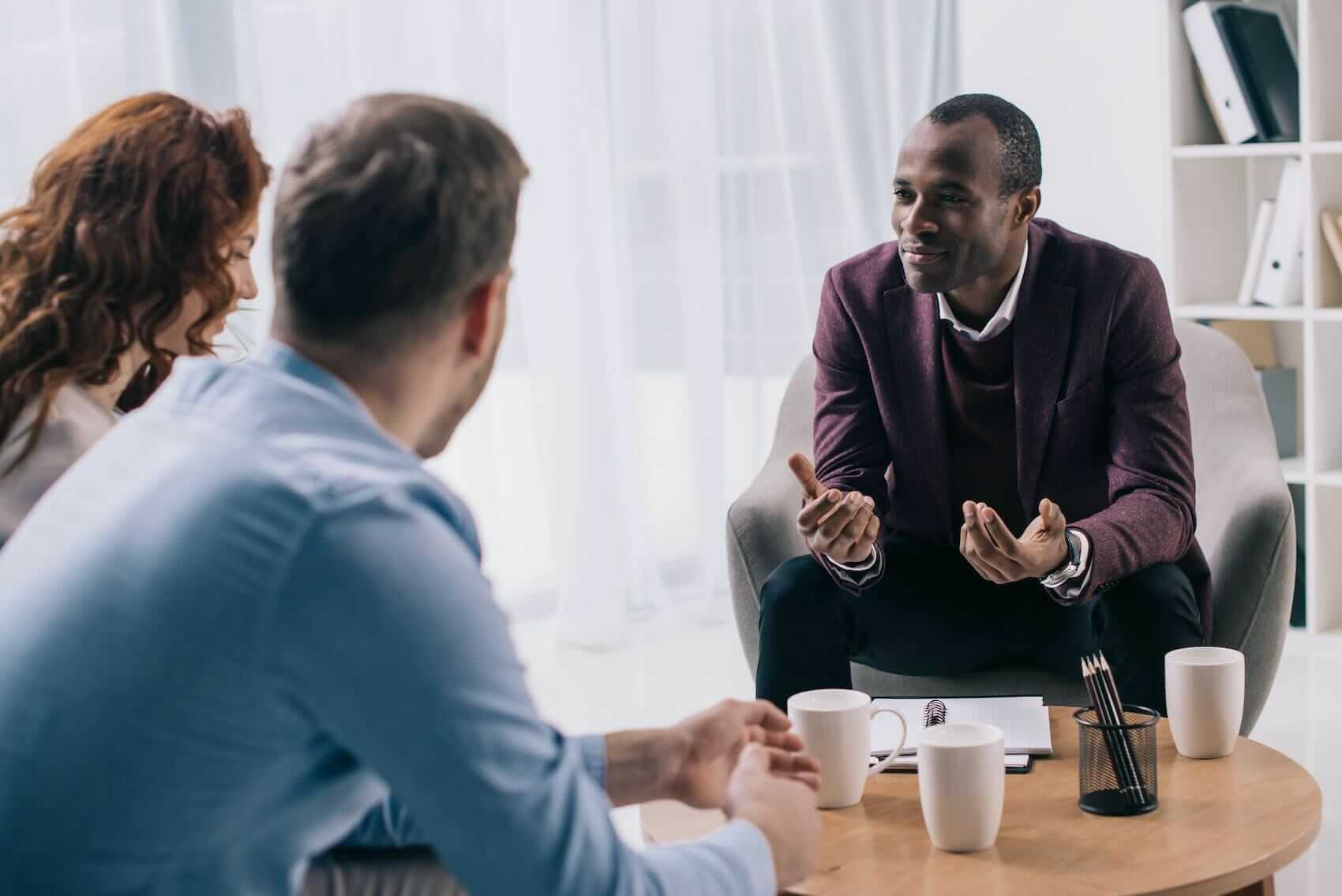 Psychologist consulting with couple in his office Mile High Psychology Example of feedback session for mental health assessment