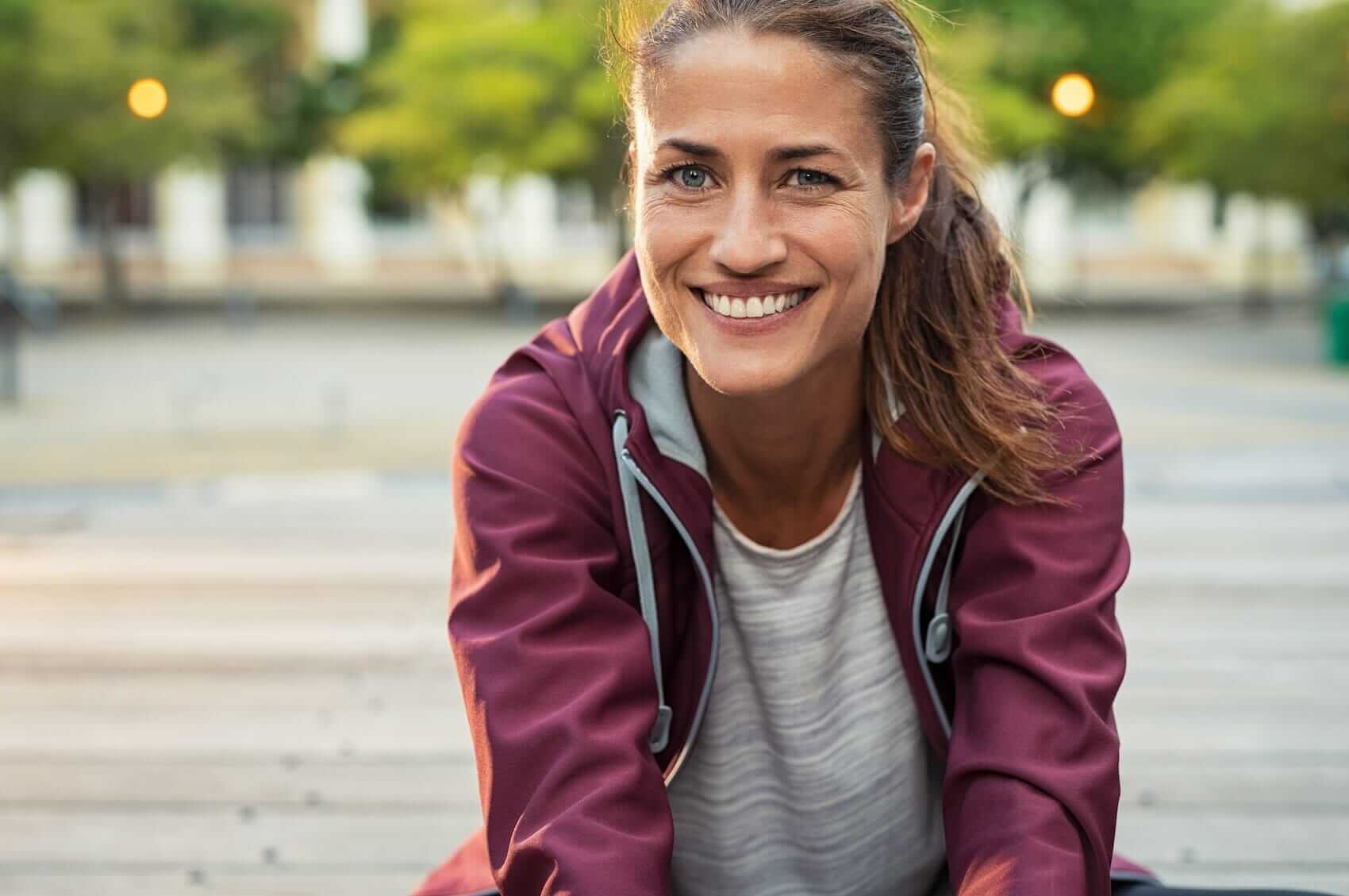 Woman stretching in city park Mile High Psychology Example of improved well being achieved by working with Colorado Springs psychologist