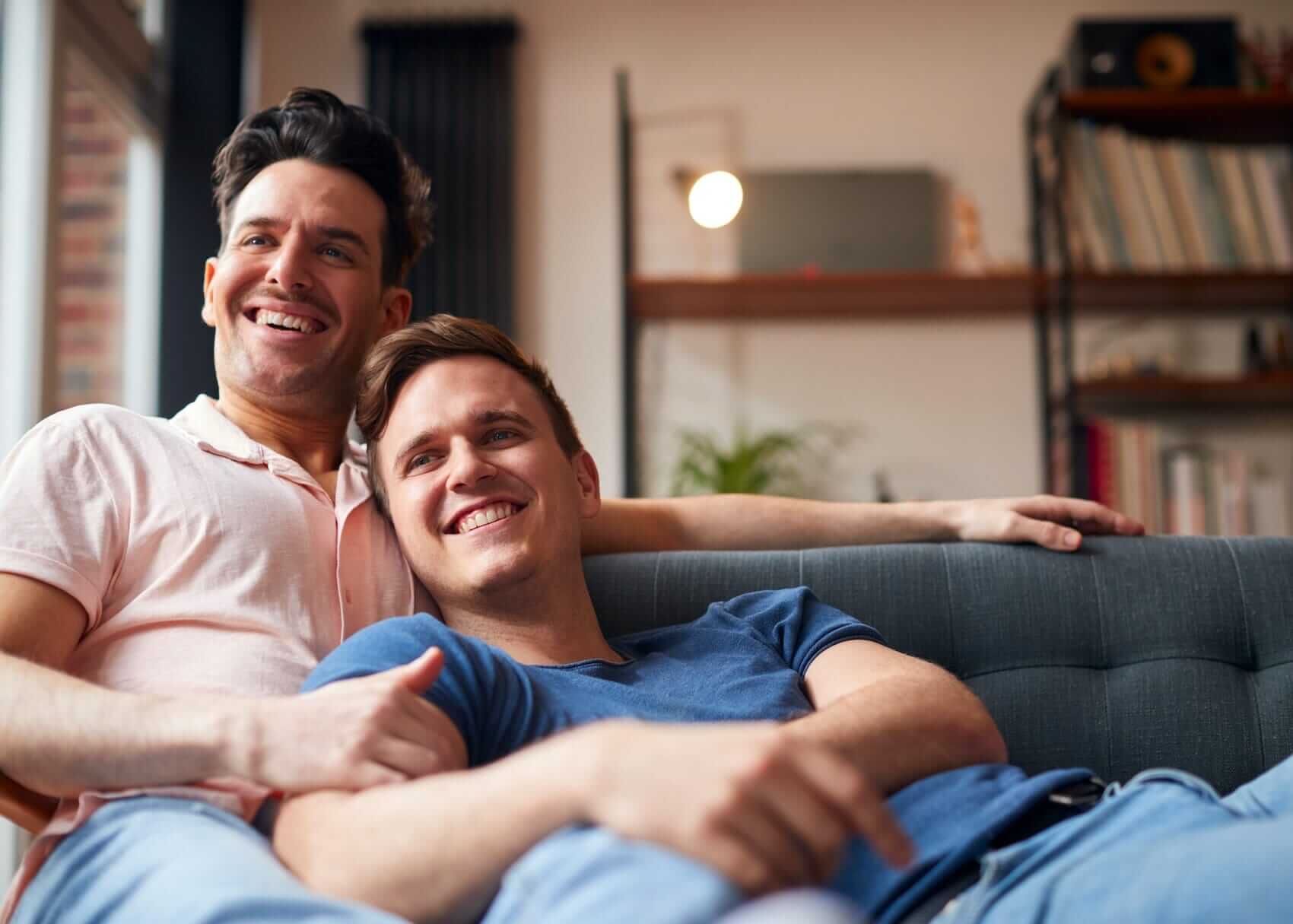 Couple watching TV Mile High Psychology Couple Lying On Sofa At Home Watching TV