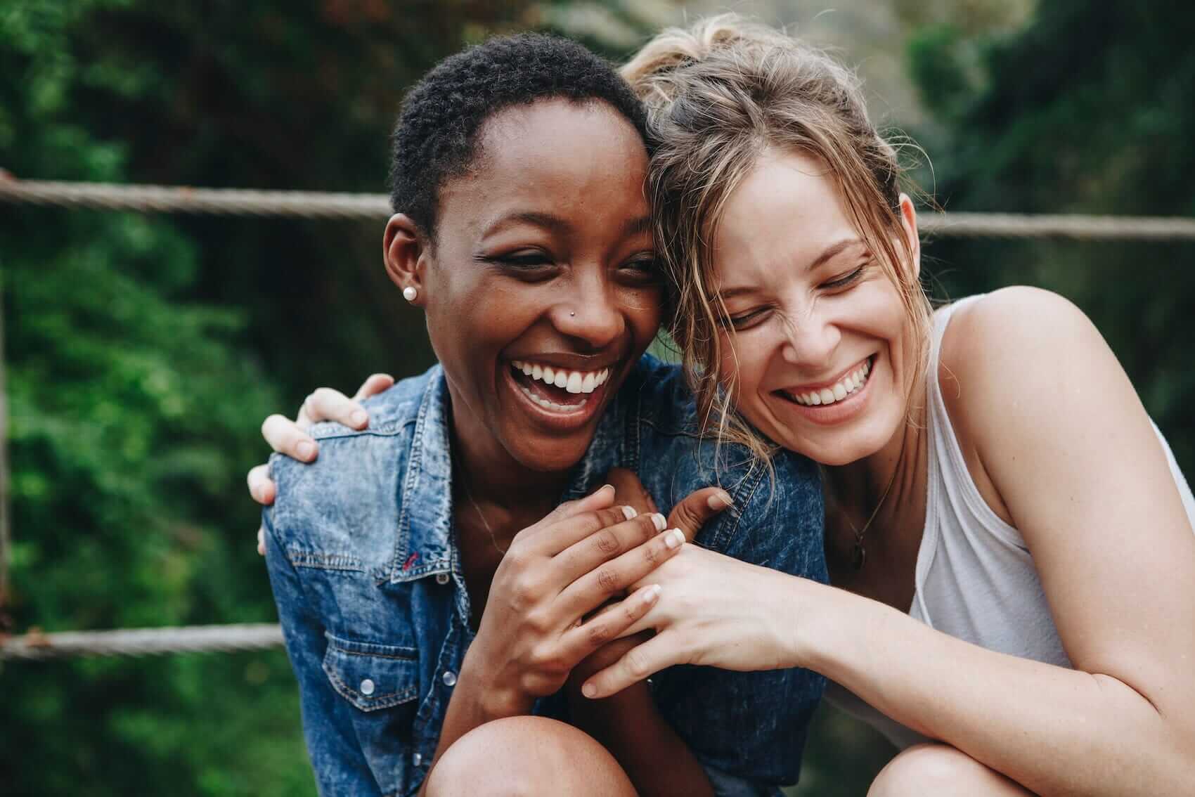 Happy friends holding each other Mile High Psychology Example of increased intimacy and connection through couples counseling