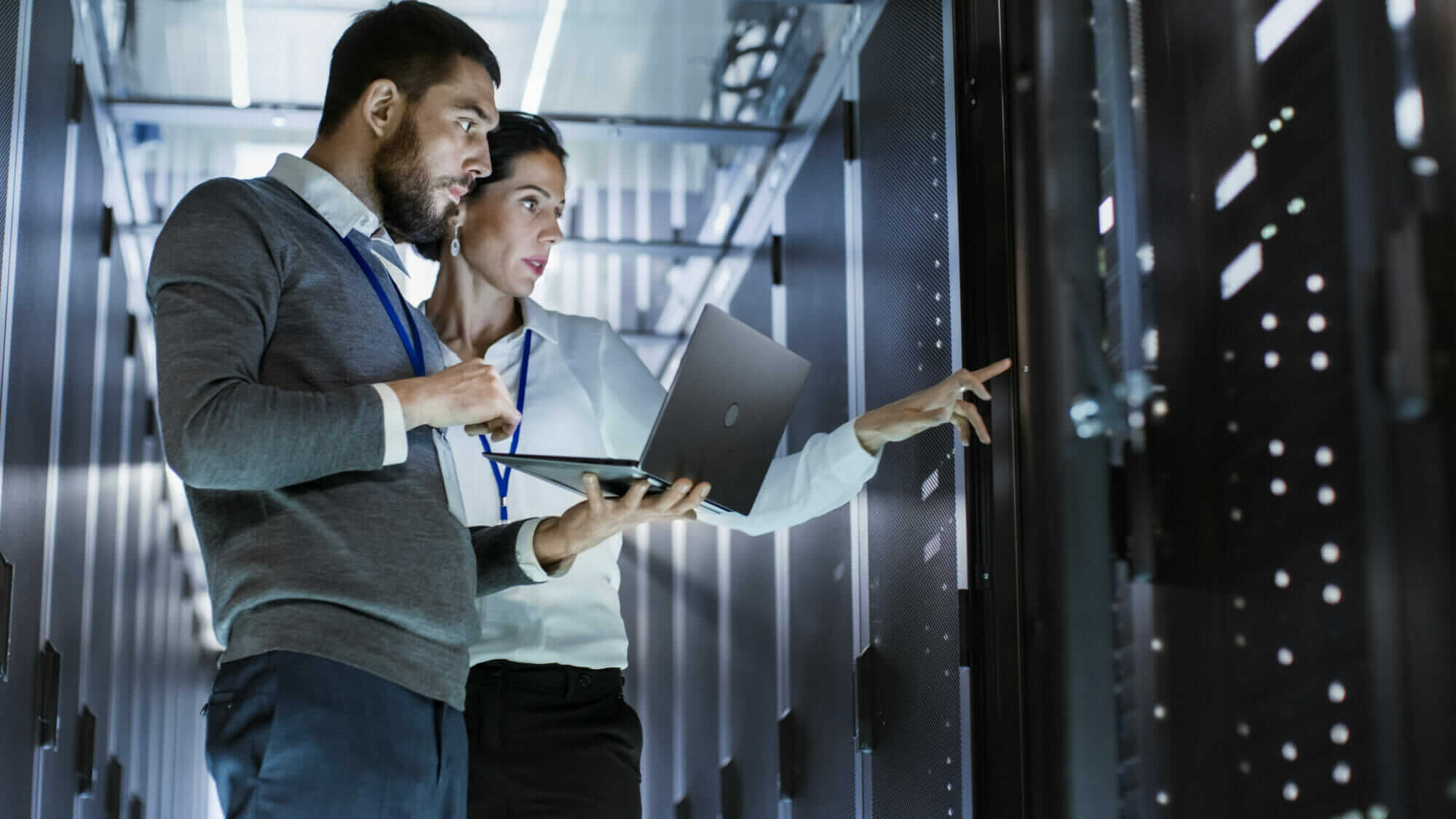 IT specialists in server room Mile High Psychology Two IT engineers examining server in data center