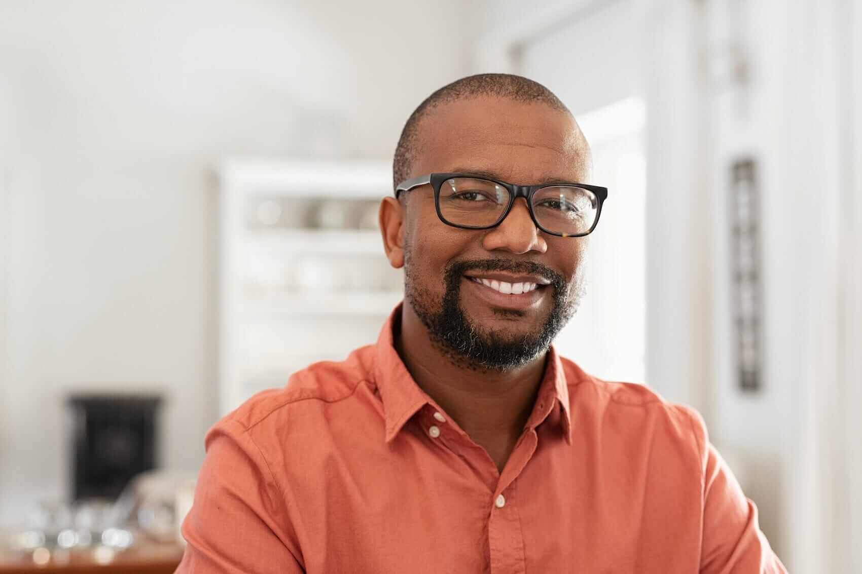 Portrait of man with glasses at home Mile High Psychology Example of feeling content and at peace through anxiety therapy