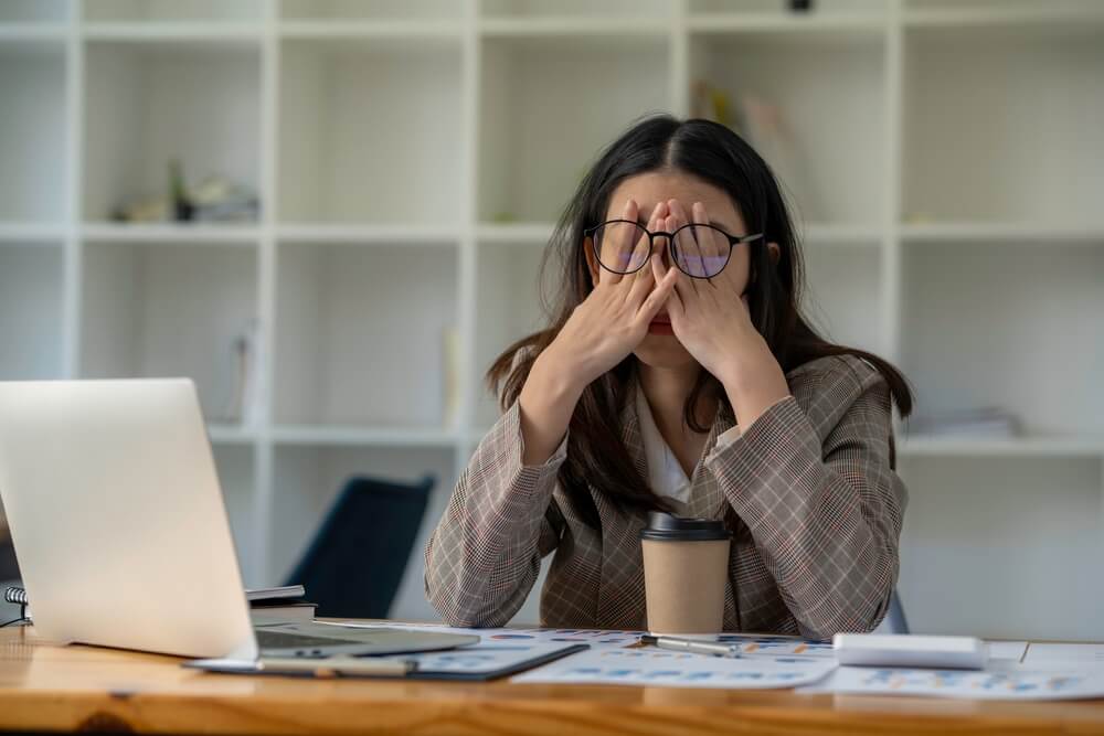 Stressed out woman at her desk Mile High Psychology Photograph of a business woman at her desk, rubbing her eyes, showing she is tired and stressed out.
